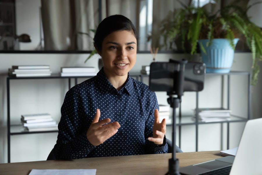 Smiling,Indian,Ethnic,Girl,Sitting,In,Front,Of,Smartphone,On woman speaking well in an online meeting